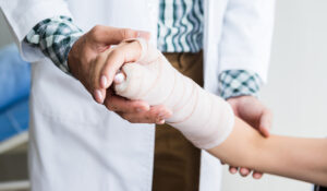 Doctor holding patients broken arm in cast